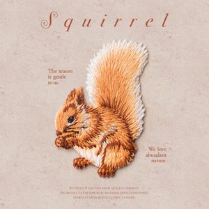 May include: Embroidered iron-on patch of a brown squirrel with a bushy tail, holding a nut. The patch has the text "Squirrel" at the top and "The season is gentle to us. We love abundant nature." at the bottom.