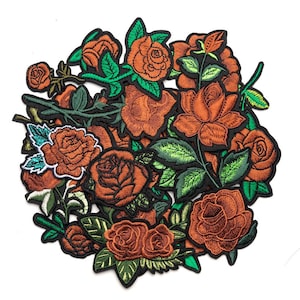 May include: A collection of embroidered iron-on patches featuring orange roses with green leaves and stems. Each patch has a black border and detailed stitching, showcasing various rose blooms and buds arranged in a dense, overlapping cluster.