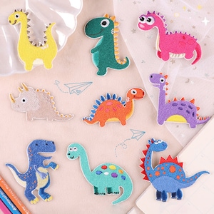 May include: Set of ten colourful embroidered iron-on patches featuring different dinosaurs. The patches are perfect for adding a fun and whimsical touch to clothing, bags, or other fabric items.