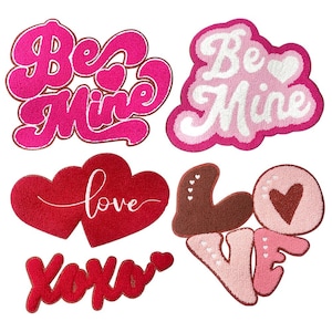 May include: Set of six Valentine's Day themed doormats with various phrases and designs. The doormats feature the phrases "Be Mine", "Love", and "XOXO" in pink, red, and white.