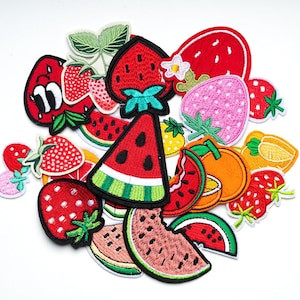 May include: A selection of fruit-themed embroidered patches, featuring strawberries, watermelon slices, and an orange segment. The patches are in red, green, pink, and orange, perfect for customising clothing or accessories.