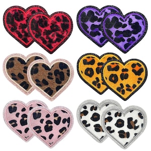 May include: Set of ten iron-on patches in the shape of hearts. Each heart is made of two pieces, with a leopard print design in different colors. The colors include red, purple, yellow, brown, and pink.