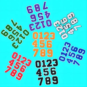 May include: A set of nine colourful felt patches with numbers 0-9. The patches are arranged in a circular pattern with the numbers 0-9 in each row. The patches are on a light blue background.
