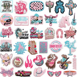 Op de afbeelding: Een verzameling geborduurde patches met een cowgirl-thema. De patches tonen verschillende ontwerpen, waaronder cowboyhoeden, laarzen, paarden en tekst zoals "Cowgirl" en "Future Cowgirl". Het kleurenpalet omvat roze, turquoise en bruin.