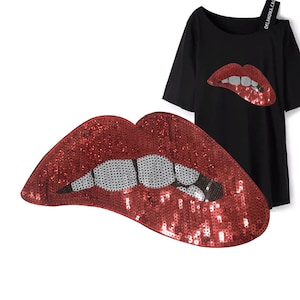 May include: Red sequin lips with a white and black tooth design. The lips are a large, bold statement piece.