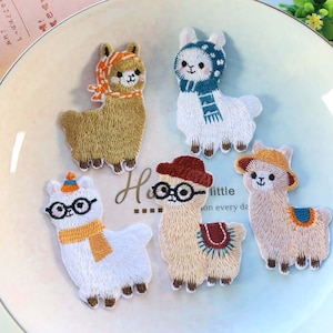 May include: Embroidered llama patches in various colors, each wearing different accessories like hats, scarves, and glasses. The llamas are arranged on a light-colored plate. The text "little on every da" is visible.