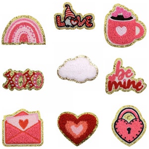 May include: Nine iron-on patches with a Valentine's Day theme. The patches are pink, red, and white with gold glitter accents. The patches feature a rainbow, a gnome, a coffee cup, a cloud, a heart, a lock, an envelope, and the words "Love", "XOXO", "Be Mine".