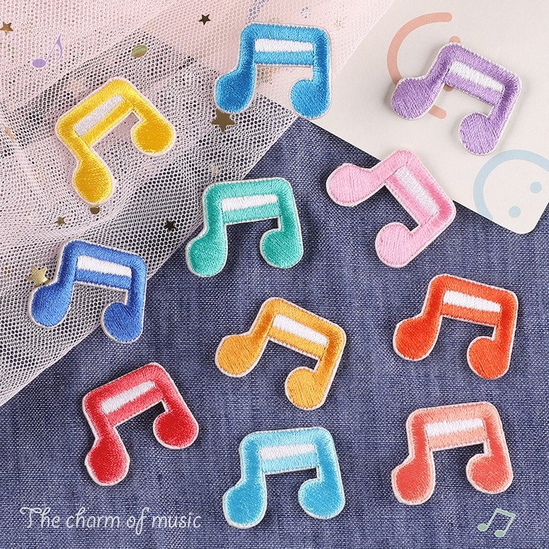 May include: Assortment of colourful iron-on patches shaped like musical notes. The patches are in various colours, including blue, yellow, orange, pink, purple, and red. The patches are perfect for adding a touch of personality to clothing, bags, or other fabric items.