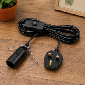 May include: A black electrical cord featuring a three-prong plug, an inline rocker switch, and a lamp socket with two attached metal spring clips. The cord is coiled into a loop, and the socket is designed for a standard light bulb connection.