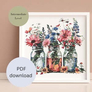 Könnte beinhalten: Drei Glasvasen gefüllt mit bunten Wildblumen, darunter rosa, blaue und weiße Blüten. Die Vasen sind in einer Reihe auf weißem Hintergrund angeordnet. Das Bild ist mit einem weißen Rahmen gerahmt.