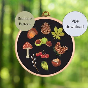 Könnte beinhalten: Ein schwarz-weißes Kreuzstichmuster mit herbstlichen Elementen wie Pilzen, Eicheln, Blättern und Tannenzapfen. Das Muster ist mit "Anfängermuster" gekennzeichnet und als PDF-Download verfügbar.