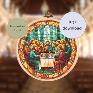 Könnte beinhalten: Ein runder, hölzerner Stickrahmen mit einem farbenfrohen Kreuzstich-Design, das das letzte Abendmahl darstellt. Das Design zeigt Jesus und seine Jünger, die um einen Tisch sitzen, mit einem Effekt aus Buntglasfenstern. Der Rahmen ist mit "PDF-Download" und "Mittleres Niveau" beschriftet.