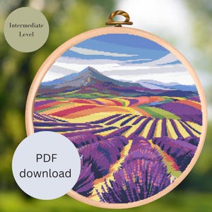 Könnte beinhalten: Kreuzstichmuster eines Lavendelfeldes mit einem Berg im Hintergrund. Das Muster befindet sich in einem hölzernen Stickrahmen und hat einen blauen Himmel mit weißen Wolken. Der Text "PDF-Download" befindet sich auf einem blauen Hintergrund.