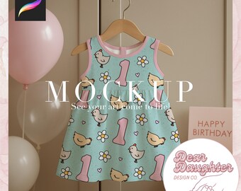 Könnte beinhalten: Ärmelloses Babykleid mit hellblauem Hintergrund, mit einem Muster aus gelben Küken, weißen Blumen und der Zahl "1" in Rosa. Das Kleid hängt an einem Holzbügel. Das Bild enthält den Text "MOCKUP" und "See your art come to life!"