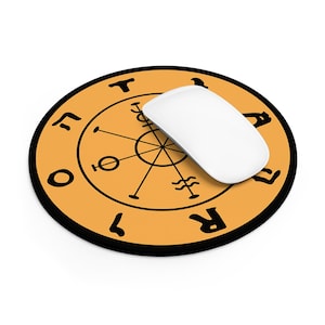 May include: A round orange mouse pad with a black border featuring a central black circular diagram with radiating lines and symbols. The text TAROT is printed in black along the outer edge. A white computer mouse rests on the surface.