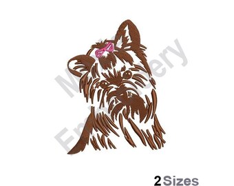 Könnte beinhalten: Gestickte Darstellung eines braunen Yorkshire Terriers mit einer rosa Schleife. Der Hund schaut nach rechts. Das Design ist in zwei Größen erhältlich.