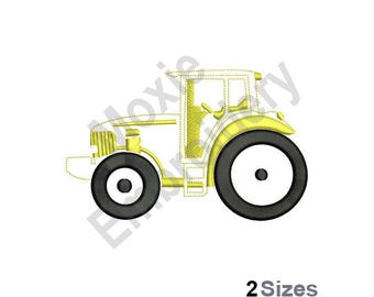 Puede incluir: Diseño de bordado de tractor amarillo con dos grandes ruedas negras. El diseño está contorneado en negro y tiene un interior blanco.