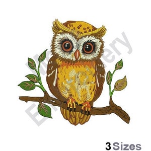 May include: Embroidered design of a brown and yellow owl perched on a branch with green leaves. The owl has large, round eyes and a detailed pattern on its feathers.