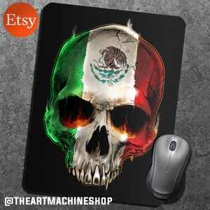 May include: A black mouse mat with a skull design featuring the Mexican flag. The skull is depicted with flames and the flag is displayed on the front of the skull.
