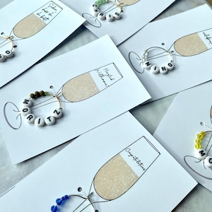 Glazen marker Glazen marker met naam in kaartje met champagneglas - personaliseerbaar, plaatskaartje, naamkaartje - 24 kleuren - gastgeschenk
