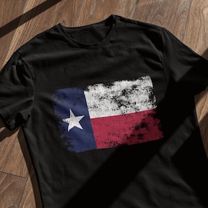 May include: Black t-shirt with a distressed, vintage-style Texas flag graphic.