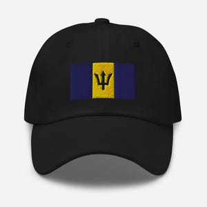 Op de afbeelding: Een zwarte baseballpet met een geborduurde gele en blauwe vlag van Barbados. De vlag heeft een zwarte drietand op een gele achtergrond.