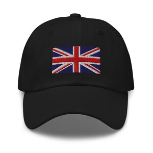 May include: Black baseball cap featuring an embroidered Union Jack flag. The flag design includes red and white stripes on a blue background. The cap has a curved peak and a button on the crown.
