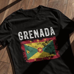 Może przedstawiać: Czarny T-shirt z przetartym białym nadrukiem flagi Grenady i napisem "GRENADA" nad nią.