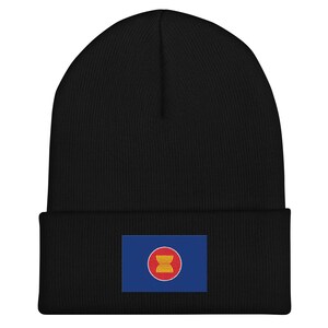 May include: Black beanie with a small embroidered flag of Cambodia on the front. The flag is blue with a red circle in the centre and a yellow stylised building inside the circle.