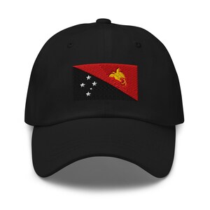 Peut inclure: Casquette de baseball noire avec un drapeau de Papouasie-Nouvelle-Guinée brodé. Le drapeau présente un fond rouge et noir avec un oiseau de paradis jaune et cinq étoiles blanches.