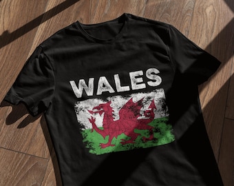 May include: Black t-shirt with a white distressed print of the Welsh flag and the word "WALES" above it.