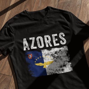 May include: Black t-shirt with a white distressed graphic of the flag of the Azores and the word "AZORES" in white.