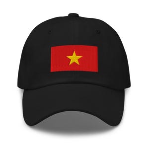 Peut inclure: Une casquette de baseball noire avec un drapeau vietnamien rouge et jaune brodé sur le devant.