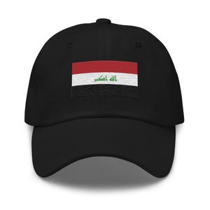 Może przedstawiać: Czarna czapka bejsbolówka z haftowaną flagą Iraku. Flaga ma czerwony, biały i czarny wzór z arabskim tekstem "Allahu Akbar" w kolorze zielonym.