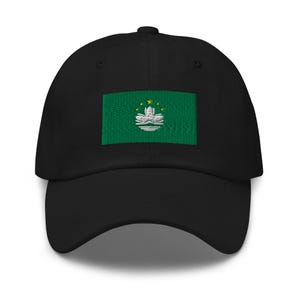May include: A black baseball cap featuring an embroidered green flag of Macau. The flag depicts a white lotus flower with five yellow stars.