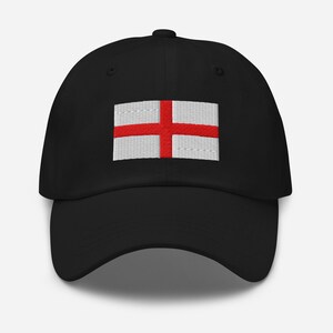 Könnte beinhalten: Eine schwarze Baseballkappe mit einer weißen und roten gestickten Flagge Englands auf der Vorderseite.