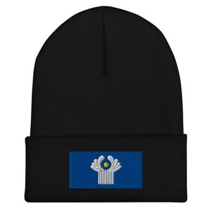 May include: Black beanie with a blue and white embroidered patch featuring a stylised white flower with a yellow centre.