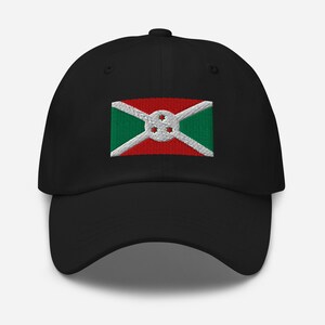 Pode incluir: Um boné de beisebol preto com uma bandeira do Burundi bordada. A bandeira é vermelha, verde e branca com uma estrela branca no centro.