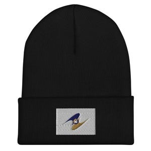 May include: Black beanie with a white patch featuring a blue and gold logo. The logo is a stylised design with a curved shape and a circle in the centre.