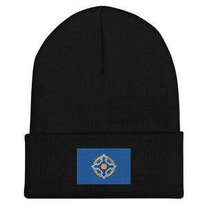 May include: Black beanie with a blue and yellow embroidered patch featuring a stylised star design.