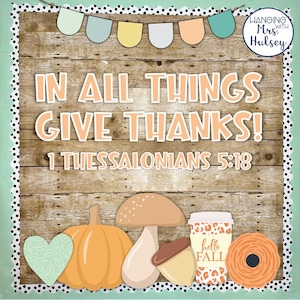 May include: A wooden background with the text "IN ALL THINGS GIVE THANKS!" and "1 THESSALONIANS 5:18". The image includes a pumpkin, mushroom, acorn, coffee cup with "hello FALL" text, and a heart. A banner of pastel colors is at the top.