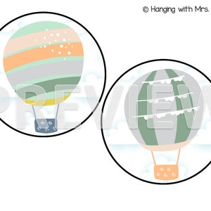 May include: Two hot air balloons with different patterns. One balloon is striped with orange, green, and gray. The other balloon is green and gray with white bunting. Both balloons are against a white background with clouds.