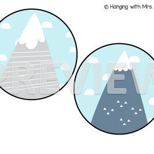 May include: Two blue and white circle designs with a gray and white mountain in each. The mountain on the left has a white snowy peak and gray stripes. The mountain on the right has a blue peak and white triangles.
