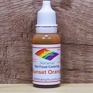 May include: A bottle of Sunset Orange gel food coloring by Bella Accents. The bottle has a white cap and a label with a rainbow design and the words "Natural Gel Food Coloring". The bottle is filled with an orange liquid.