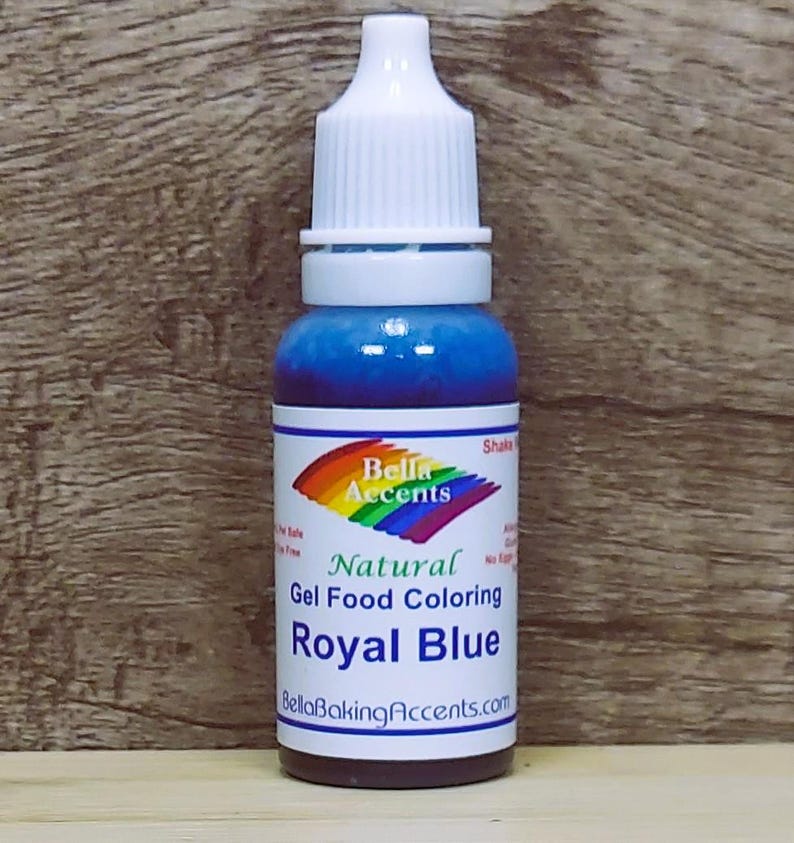 May include: A bottle of Royal Blue natural gel food coloring from Bella Accents. The bottle has a white cap and a label with a rainbow design. The liquid inside is a vibrant blue color.