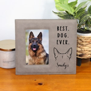 May include: A gray picture frame with a photo of a German Shepherd. The frame has the text "BEST. DOG. EVER." and a dog ear graphic. Below the graphic is the name "Sandy" in script.