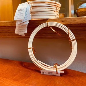 May include: A stack of white reed spline, a single coil of white reed spline, and a label that reads "#7 Reed Spline".