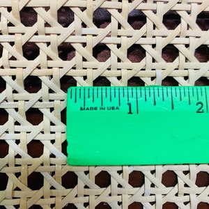 May include: Close-up of a woven cane webbing material with a ruler measuring 2.5 cm. The ruler is green with black markings and the words "Made in USA".