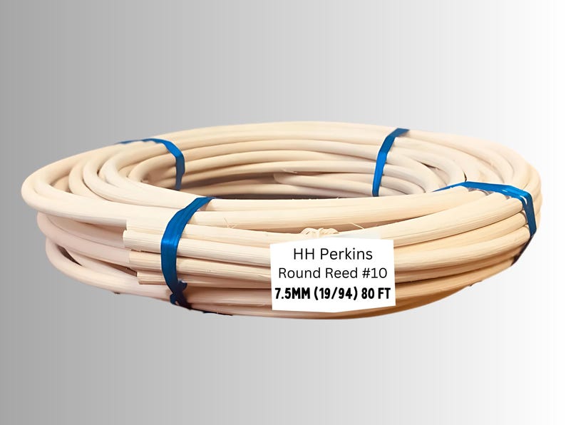 May include: Coiled round reed, secured with blue bands. The label reads "HH Perkins Round Reed #10 7.5MM (19/94) 80 FT". This natural-toned reed is likely used for weaving or basketry projects.