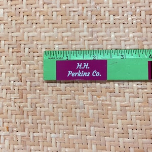 Può includere: Primo piano di un materiale tessuto in fibra naturale con un righello che misura 10 cm. Il righello è etichettato "H.H. Perkins Co."
